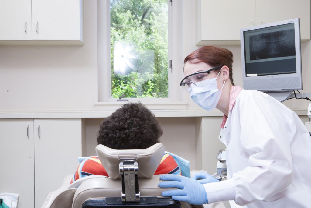 Female dentist examining patient in dental clinic