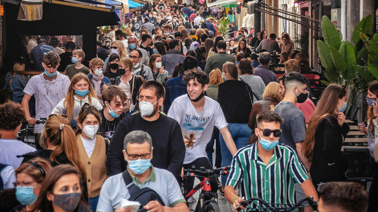 Large crowd of people wearing masks but not distancing